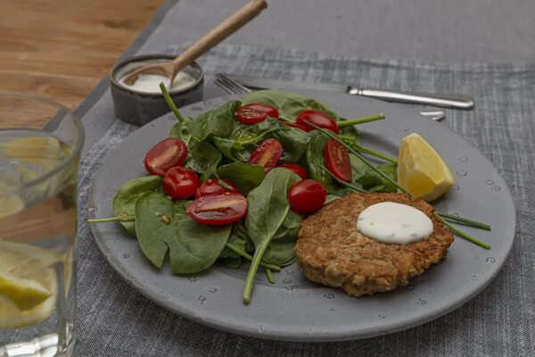 Tonijnburger met een salade van spinazie en cherrytomaten